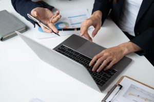 Close up view of professional businesspeople working together with laptop computer in the meeting room.